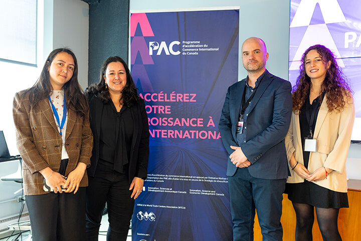 Discussion between participants and experts in front of a Trade Accelerator Program banner.