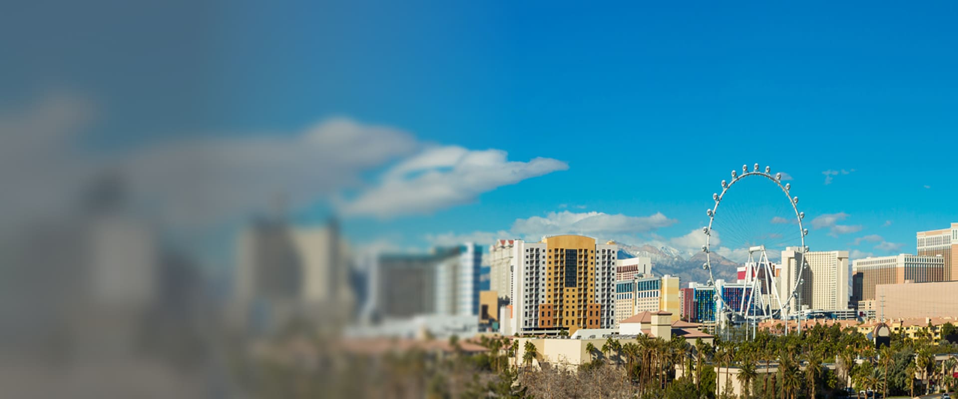 Vue panoramique de Las Vegas avec des hôtels et des immeubles en arrière-plan, et la grande roue High Roller sous un ciel bleu.