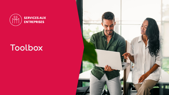 Two business professionals discussing a laptop in an office, with the text “Toolbox” for French-language services