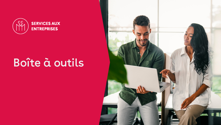 Deux professionnels discutent devant un ordinateur portable dans un bureau, avec le texte « Boîte à outils » pour la francisation