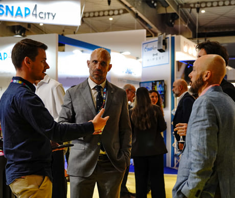 People networking at a business trade show or industry event, in an exhibition space focused on innovation and technology.