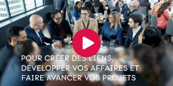 Participants gathered at a networking or business event; several people are engaged in discussion around a table in an environment that fosters professional connections and project development.
